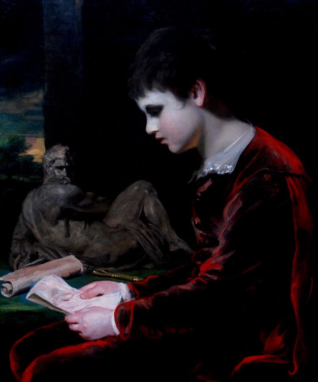 Painting. Shown from the lap up, a young boy with smooth, noticeably pale skin sits looking at a drawing, facing our left in profile. His black hair blends into the dark background. Light on his red velvet suit creates a nearly electric scarlet outline.