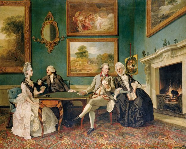 Painting. Two men and two women, all with pale skin, sit at a green felt-covered table in front of a hearth, in which a fire burns. A man and woman play cards, and are each advised by a companion of the opposite gender. Four paintings of landscapes and possibly a mythological scene hang on the teal-coloured walls.