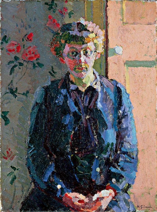 Painting. Shown from the lap up, a woman sits in front of a rose-patterned wall and a door, looking out at us with her hands in her lap. The painting is created with dabs, dashes, and touches of saturated colour. Her hair and face are painted in blocks of green, purple, pink, yellow, and red. Her clothing is painted with shades of midnight, indigo, topaz, and teal blue.