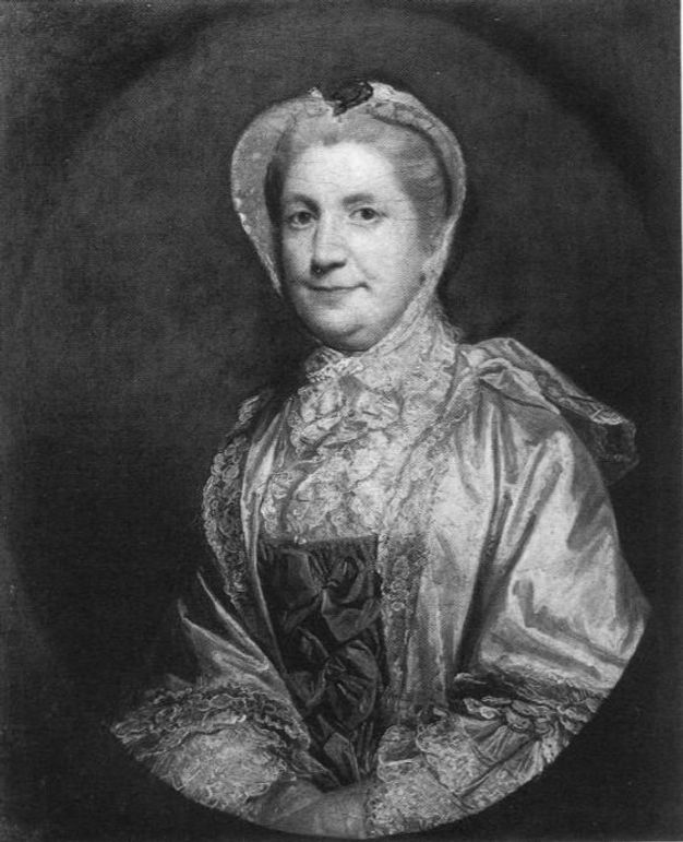 Painting. Black and white reproduction of an oval portrait of a woman shown from the waist up. She looks at us, the corners of her mouth pulled back. She wears a bonnet and shimmering shawl over an elegant dress.