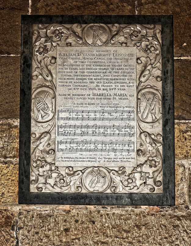 Black and white photograph. We look down onto a nave, which is packed with people. Text is printed in white against black above and below.