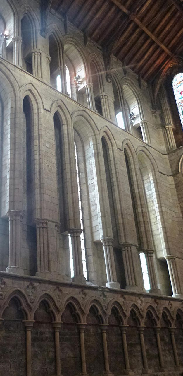Architecture. The middle and top levels of this stone church’s three storeys are pierced with arched windows. The lowest level is lined with three-lobed blind arches. Above a timbred ceiling is visible.