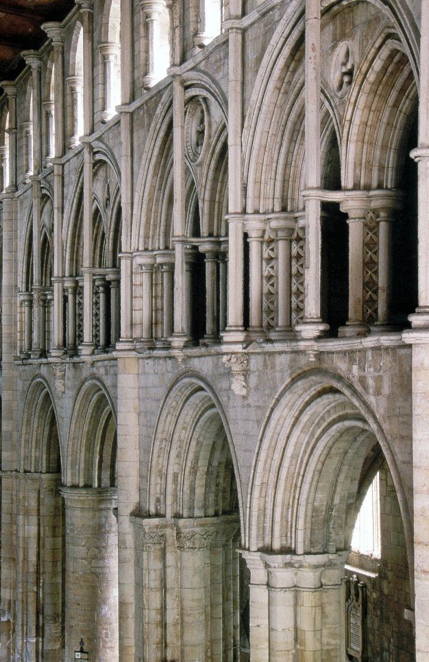 Architecture. Three levels of stone arches angle away from us to the left in this church interior. Detached shafts, commonly likened to flagpoles, have been added in front of the double arches on the middle level.
