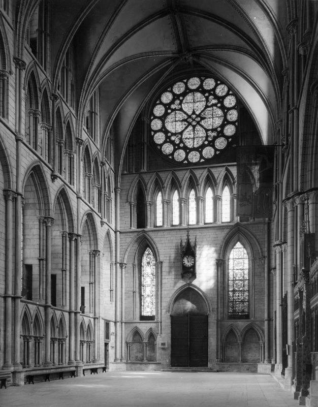 Architecture. Black and white photograph of the transept of a stone cathedral. The pointed arches are different widths, not even equal from side to side. Architectural elements also do not line up from level to level.