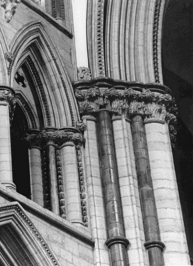 Architecture. Black and white photograph of the densely columned church crossing. Some of the elements are a darker, shinier stone against lighter, more matte stone.