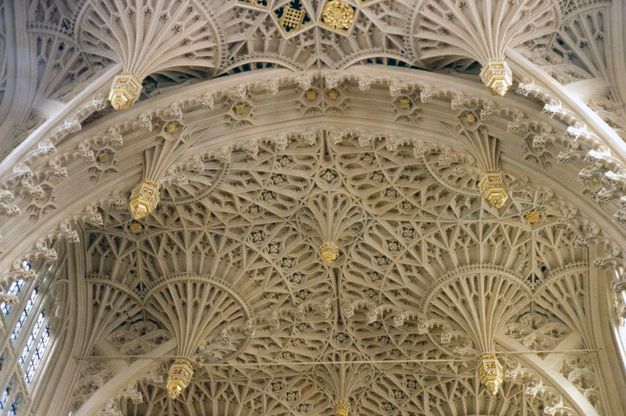 Architecture. The vaulted ceiling of a church chapel is carved into fanning, intricate, spirograph-like patterns that may, at first glance, look like handmade lace.