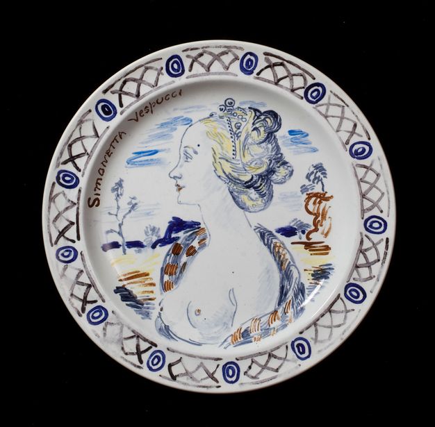 Plate. Shown from the chest up, a bare-breasted woman faces our left in profile. Her braided golden hair is looped around her head. Her body and much of the landscape behind her is painted in shades of blue with a few touches in brown and yellow. Her name is painted to the left side of the plate, \“Simonetta Vespucci\”.