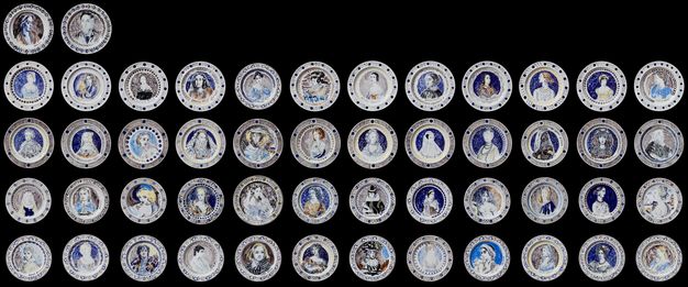 Plates. Fifty plates are arranged against a black background. Each is painted with a portrait of a women. The plates are arranged in a grid of twelve across and four down, plus two additional plates at the upper left.