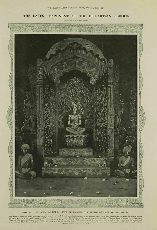 Page of a magazine. A black and white photograph of a woman and two men in Indian costumes who all sit on an elaborate set. Text along the top of the issue reads, “The Illustrated London News, Oct. 31 1908 The Latest Exponent of the Delsartian School”.