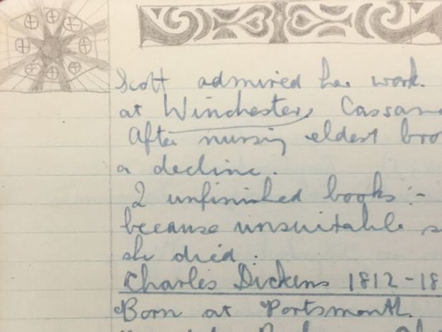 Drawing. A starburst design and curlicues around hearts are doodled in the margins of lined paper with notes in pen.