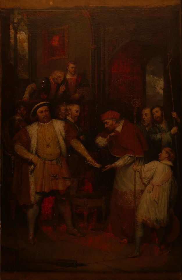 Painting. A man, Henry VIII, stands with feet widely planted, one hand on his hip as he hands a piece of paper to Thomas Wolsey, who wears red cardinal’s robes. The tones are dark and shadowy except where the red glows as the canvas is lit from behind.