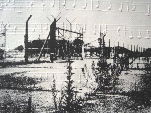 Black and white photograph of a complex behind a chain-link fence overlays or is overlaid with musical notation in raised white on white, so the notes and staff cast shadows.