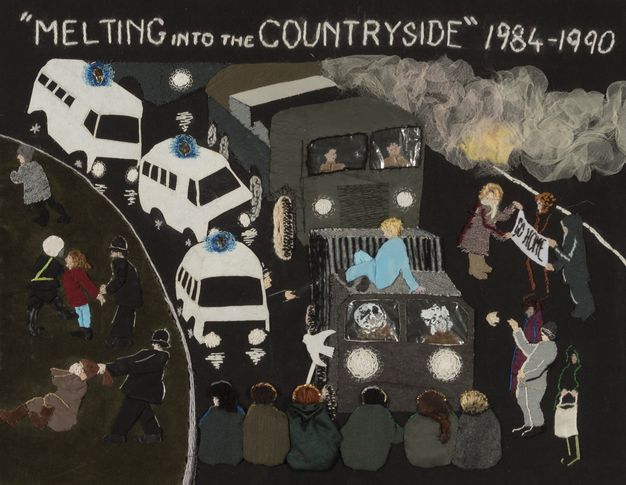 Textile. In a simplified style with blocks of colour, three white emergency vehicles with blue sirens and two armoured vehicles are stopped by a row of six people sitting in the road. Women are handcuffed or pulled by their hair by police to our left. Three people to our right hold up a sign reading 'Go home'.